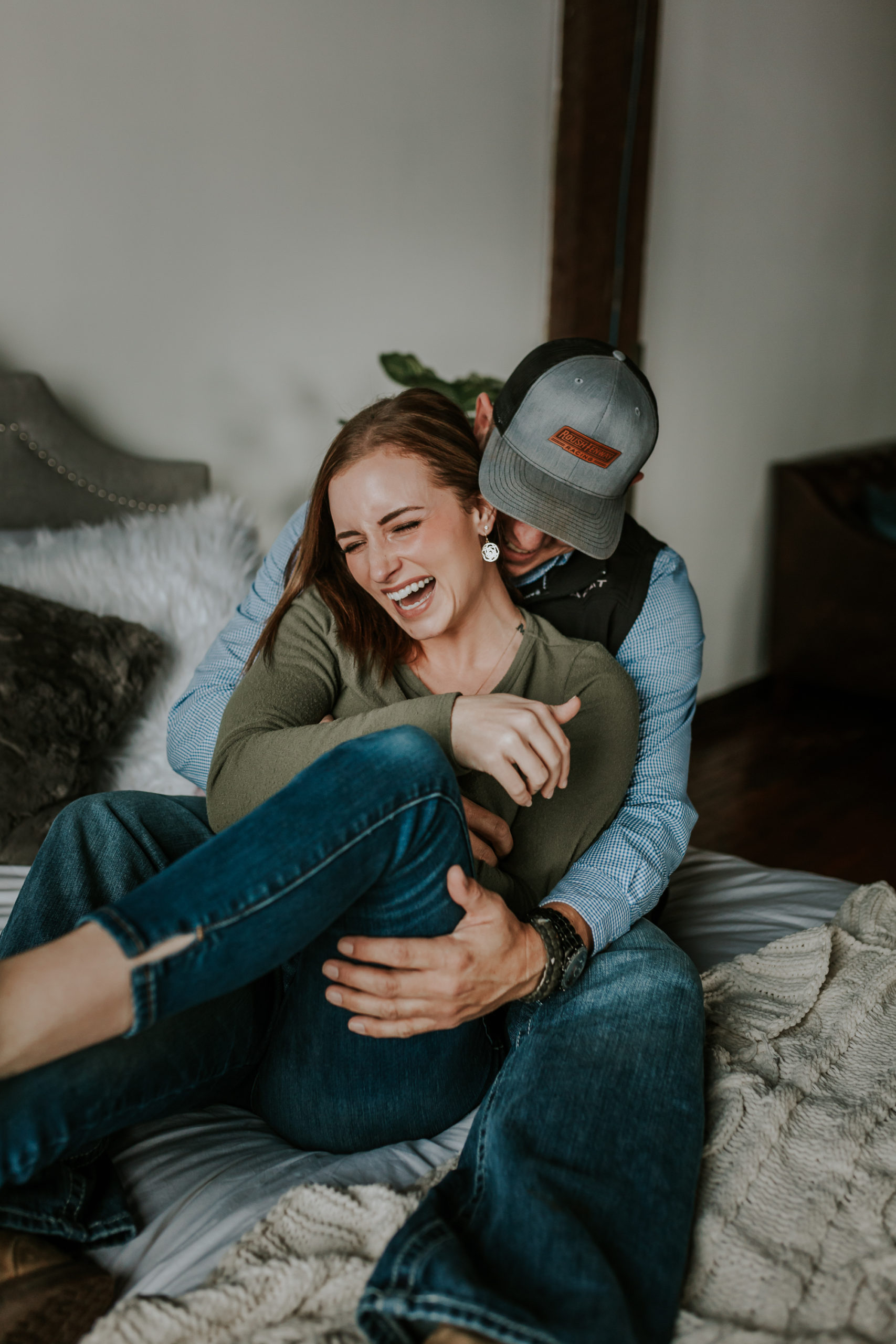 Couple laughing at their in-home winter engagement session.